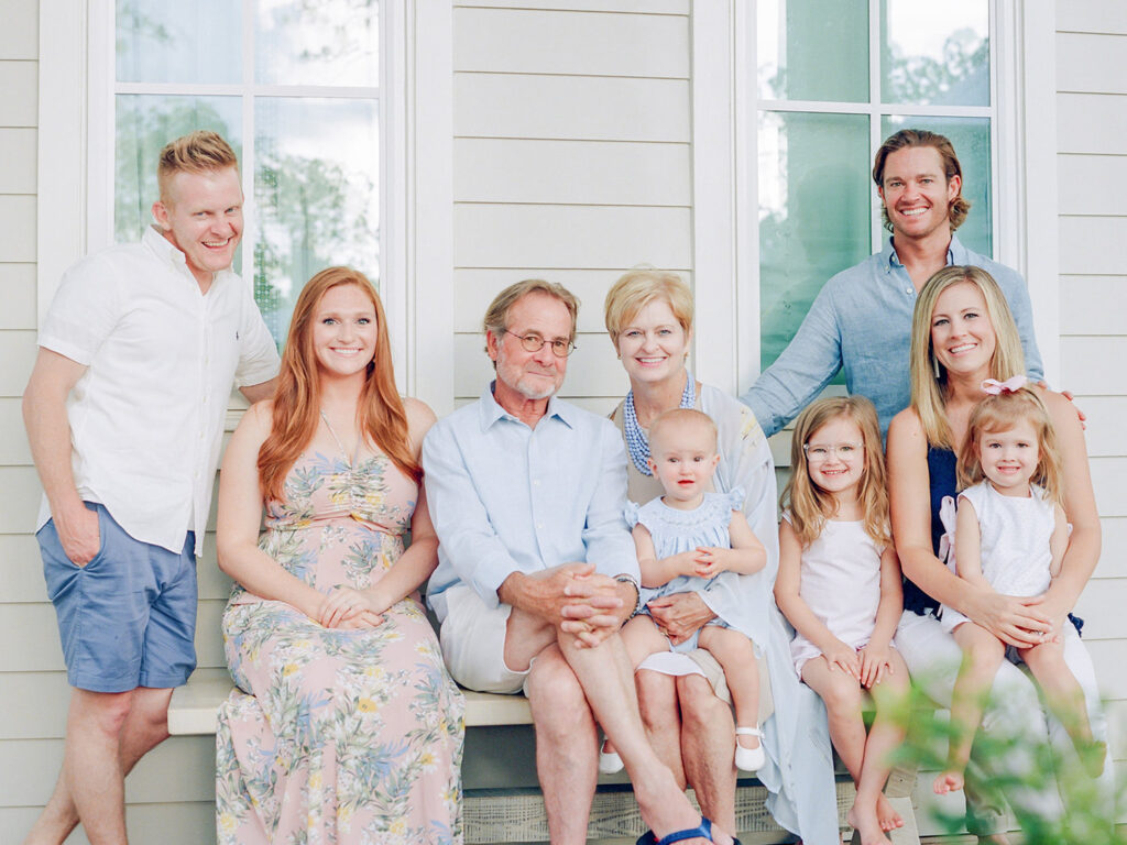 A family gathered on their front porch in 30A for photographer in Santa Rosa Beach FL to take their picture.