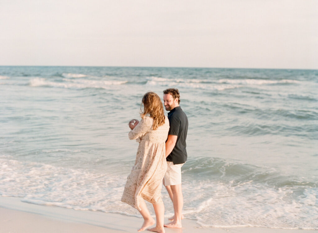 A couple walking along the shoreline in Rosemary Beach, Florida.