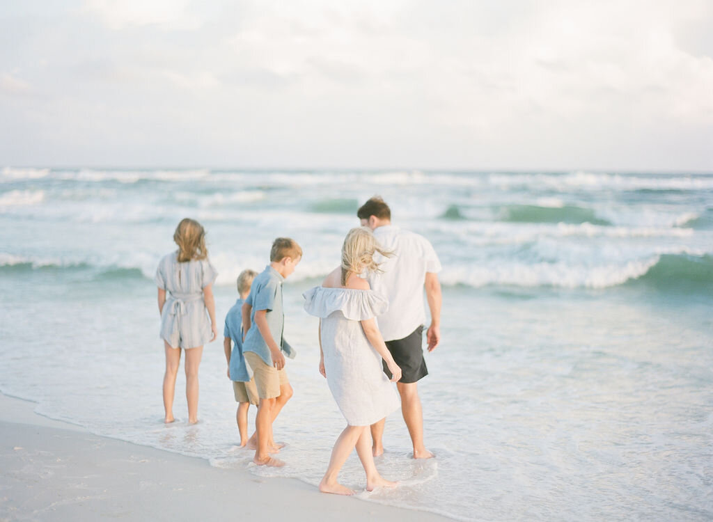 A family walks on beach in Watersound Beach, Florida. 