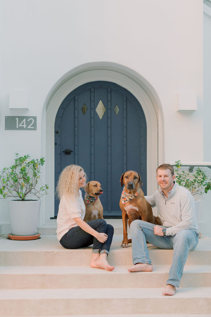 A couple with their fur babies smile for their Rosemary Beach photographers during their family photos. 
