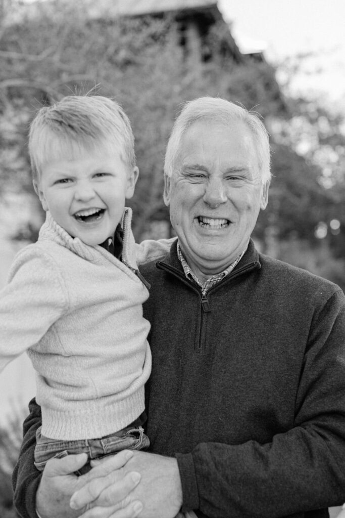 A granddad with his grandson smiling captured by their Rosemary Beach photographers. 
