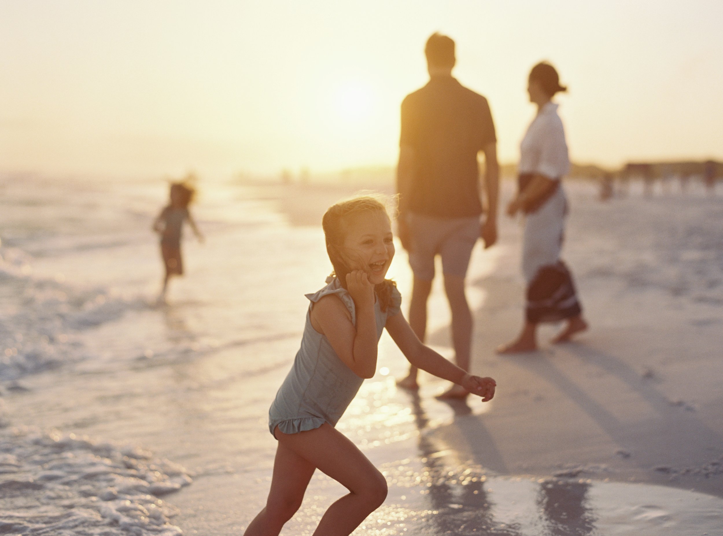 A family playing on the beach during their family photoshoot in 30A.