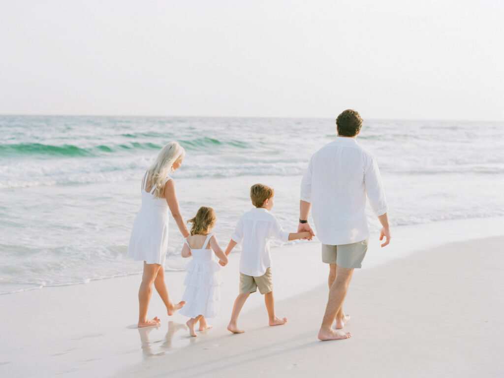 A family walking on the beach in 30A's newest community Watersound Beach. 