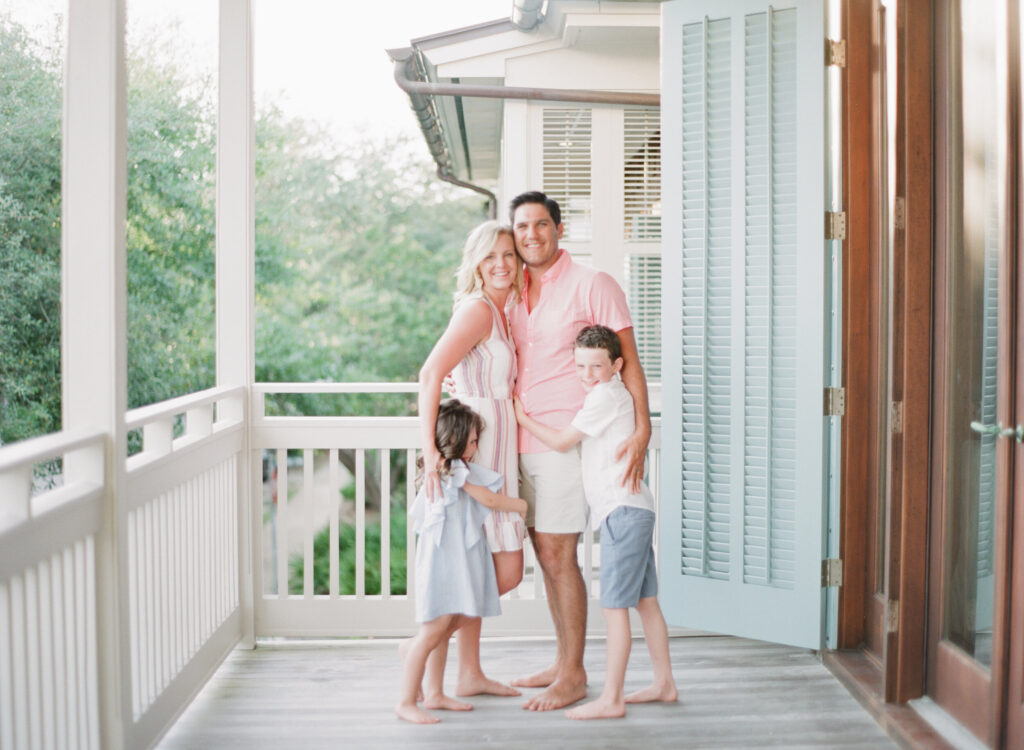 A family hugs on their beach porch in Rosemary Beach, Florida. 