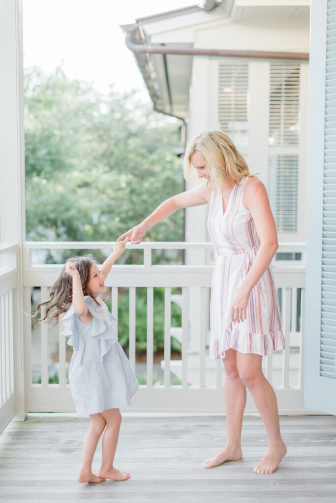 A mother twirling her daughter on the porch in 30A captured by Rosemary Beach photographers, Kaylie B. Poplin.
