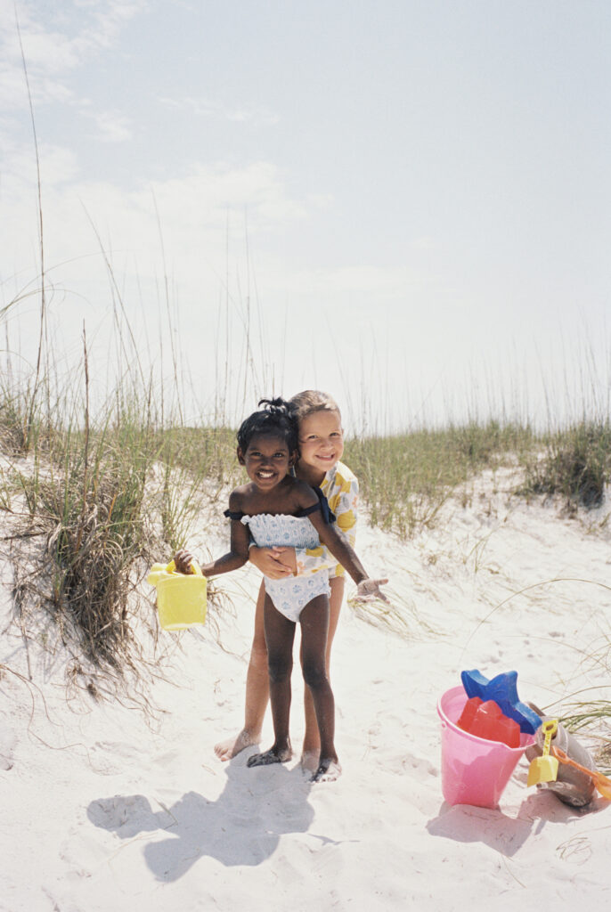 Two sisters exchange a hug with their beach toys in tow after spending an afternoon on Okaloosa Island in Fort Walton Beach, Florida.