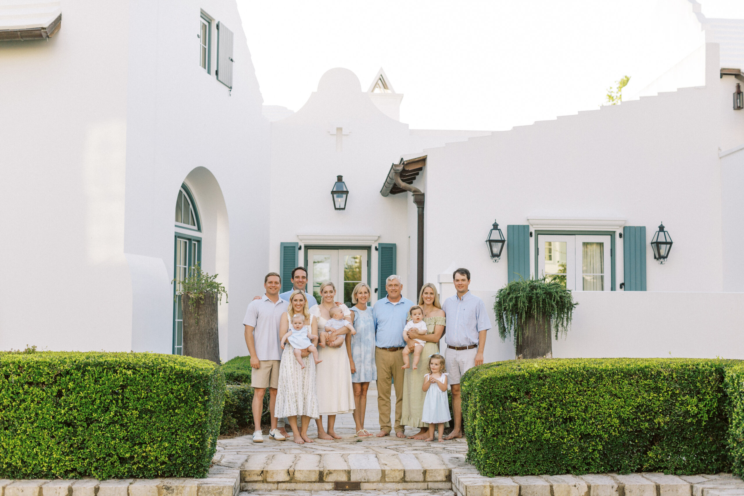 A large family stands in front of their alys beach, florida home.