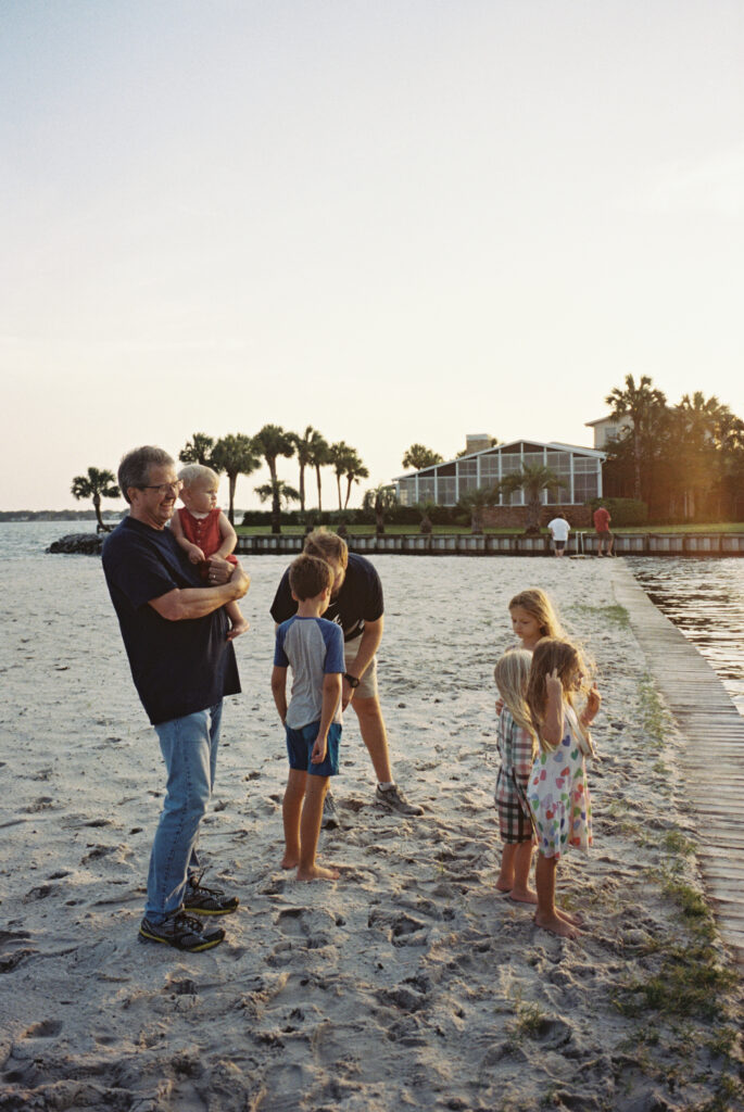 A family stands waiting for their boat to pull up as the sun sets at Meigs Park in Shalimar, Florida.