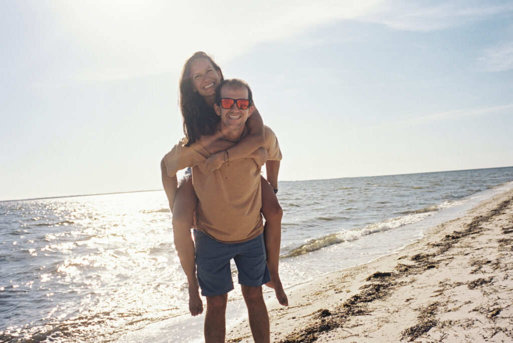 A couple smiles and plays on the beach on the forgotten coast of florida in port st joe florida. 