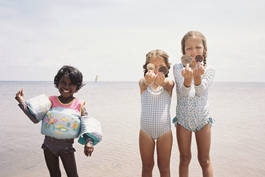 Three girls collecting sand dollars on the forgotten coast of florida.