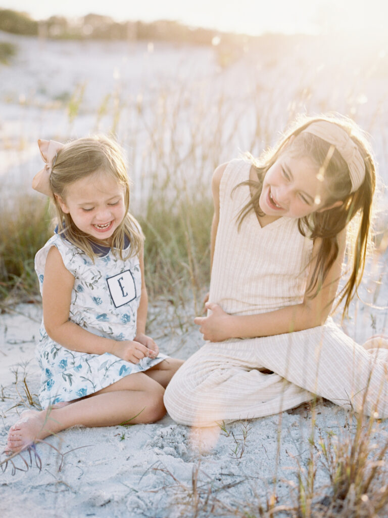 Two sisters laughing together while on vacation in grayton beach, florida.