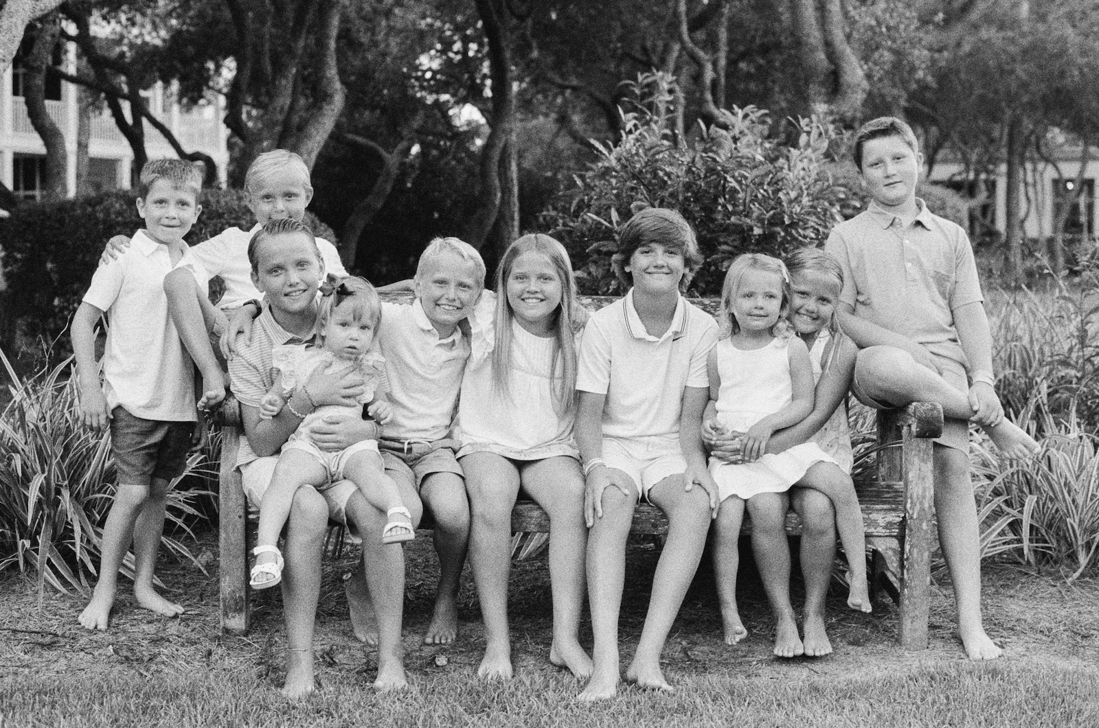 A group of cousins sitting on a bench in cerulean park in watercolor, florida.