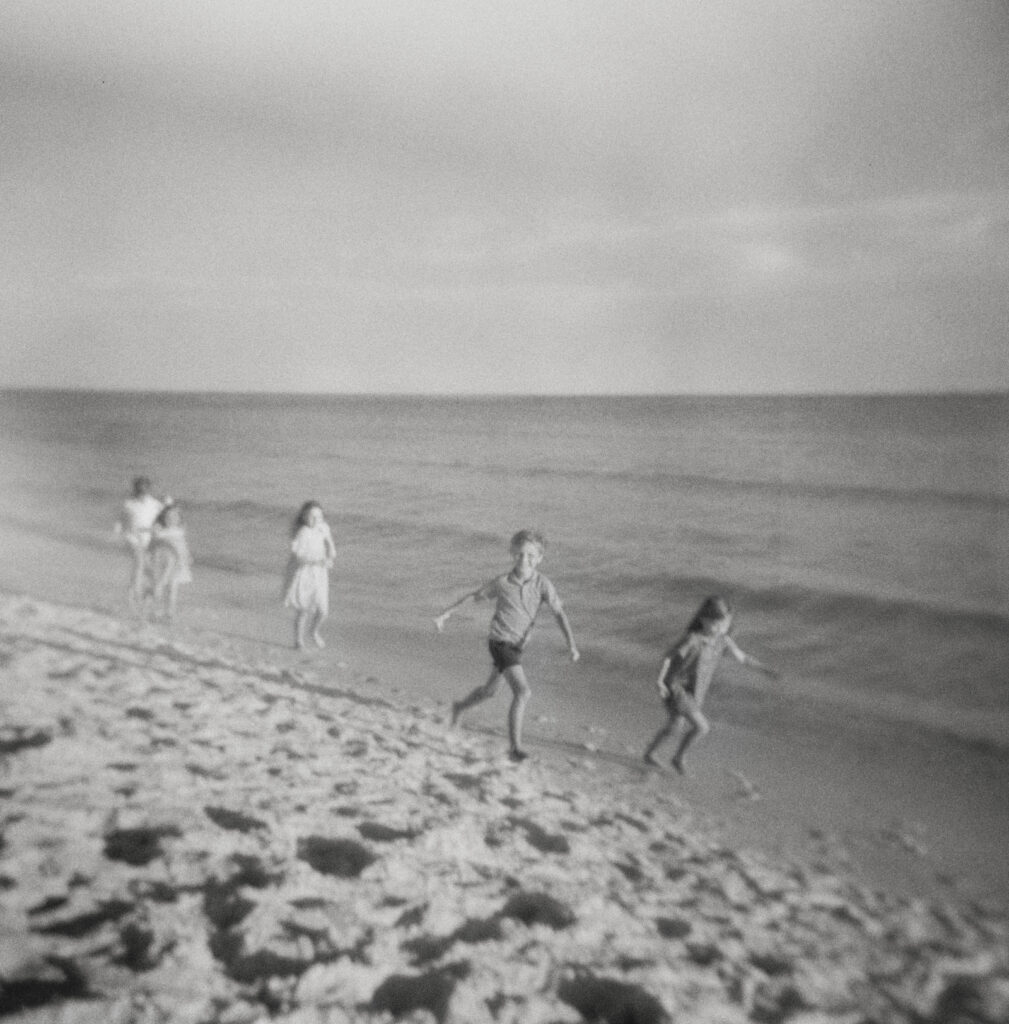 Young children race while running up and down the shoreline in Destin, Florida. 