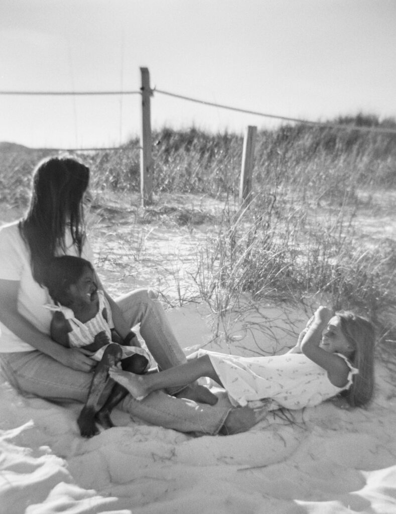 A daughter takes a photo of her mother holding her baby sister in Fort Walton Beach, Florida. 