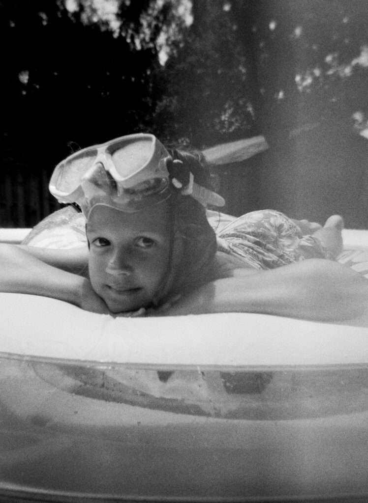 A little girl relaxing peacefully on her pool float. 