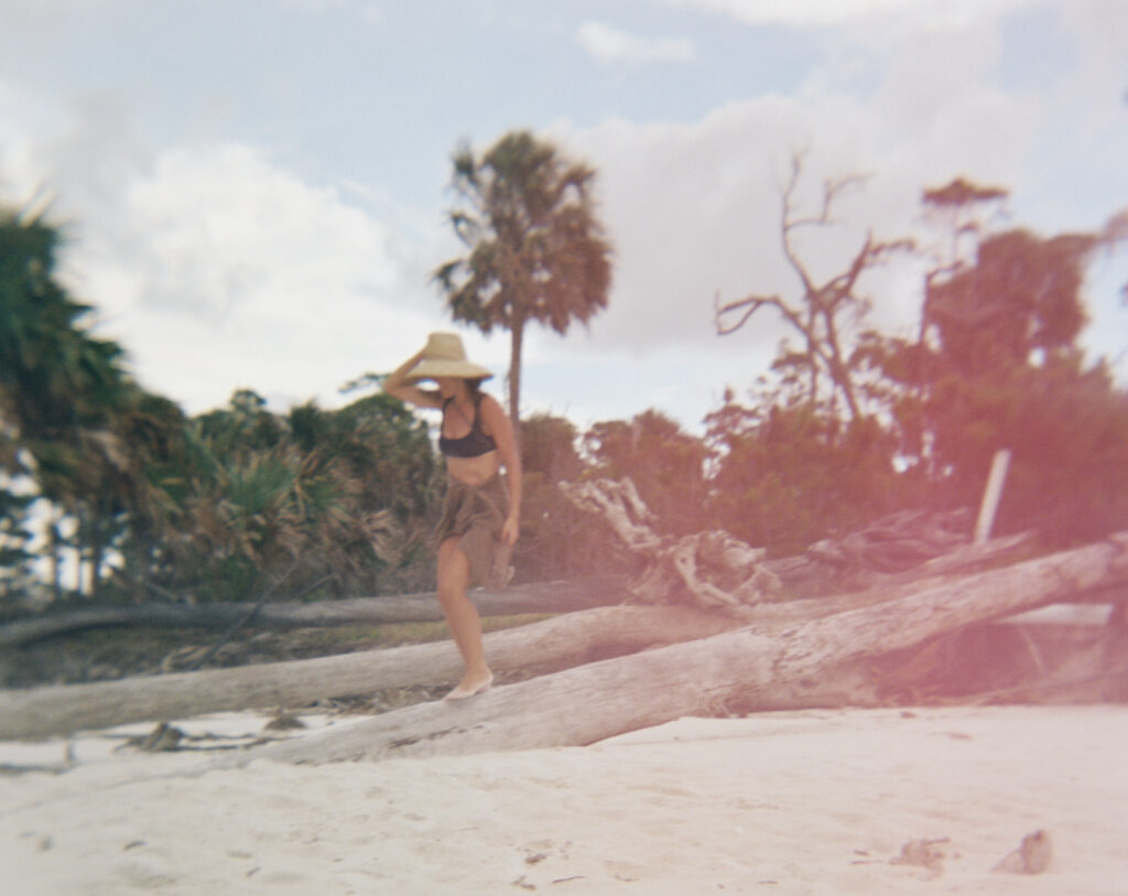 A woman walks on the beach in Cape San Blas with her brown sarong on.