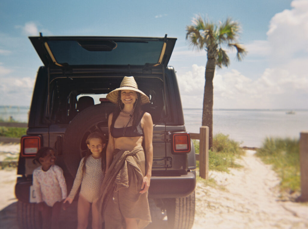 A mother and her kids stand in front of their jeep at Cape San Blas State Park.