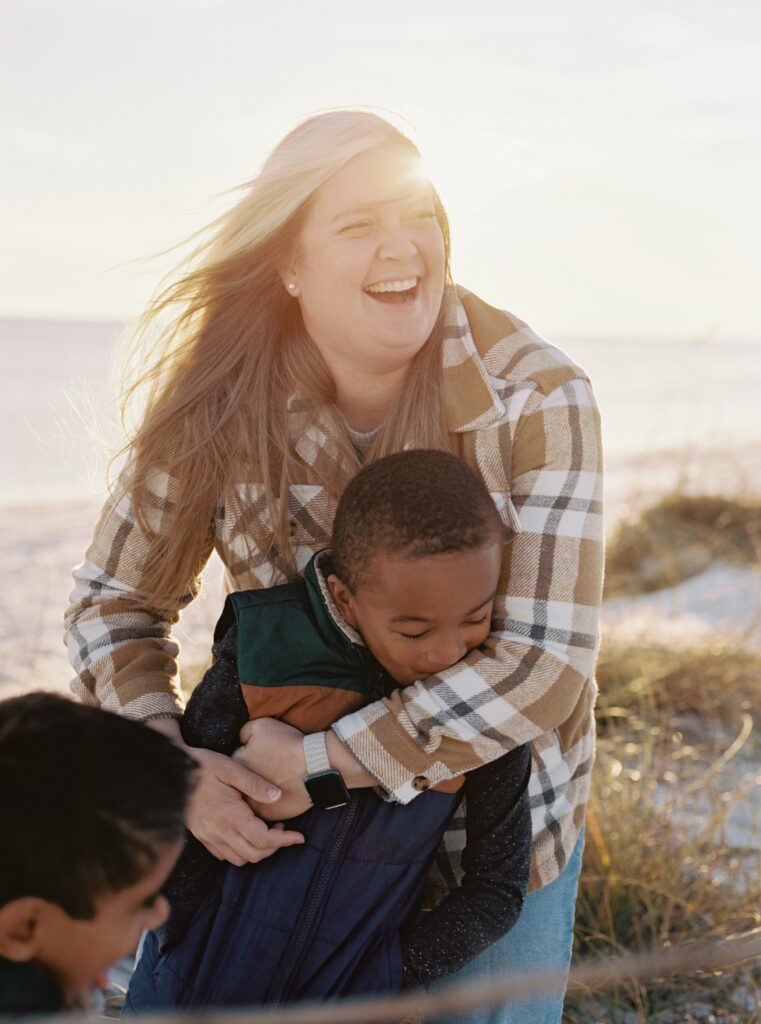 A mom laughs at her two sons playing on the beach in Destin, Florida. 