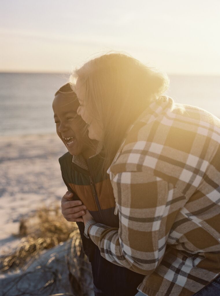 A mom and her son laugh on the beach together in Destin, FL. 